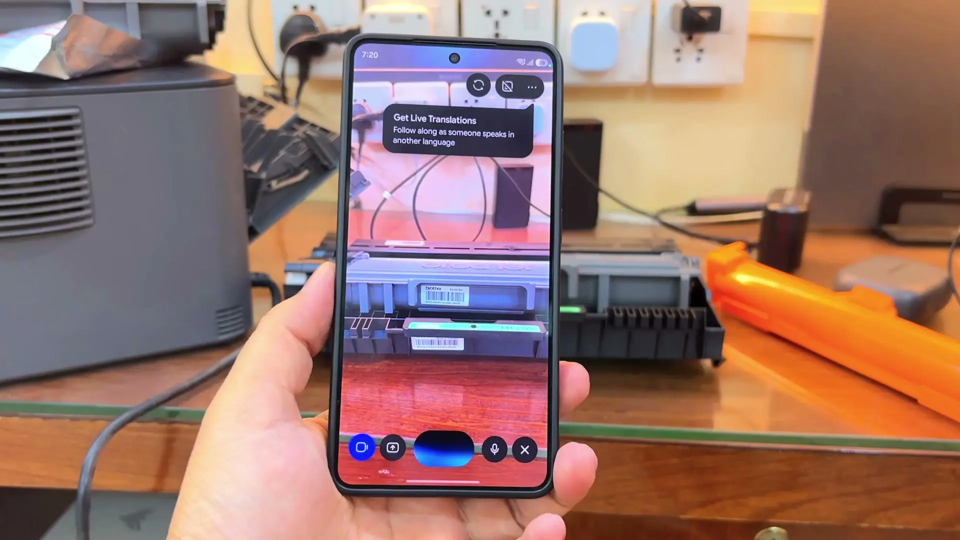 A phone camera view of the toner cartridge with an AI assistant's camera interface on screen