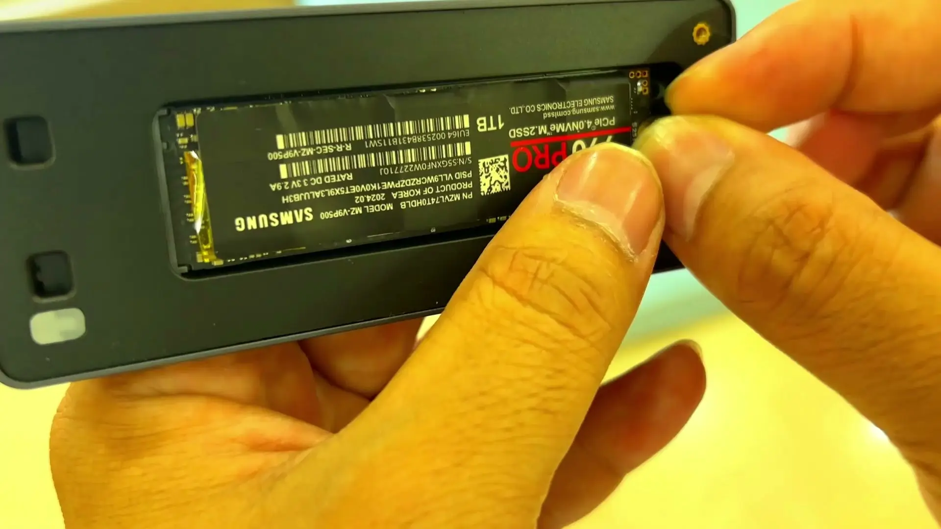 The SSD sitting in the open UGREEN enclosure, its Samsung-branded label showing model MZ-V9P500 and part number MZVL74T0HDLB, with 1TB and a red PRO mark