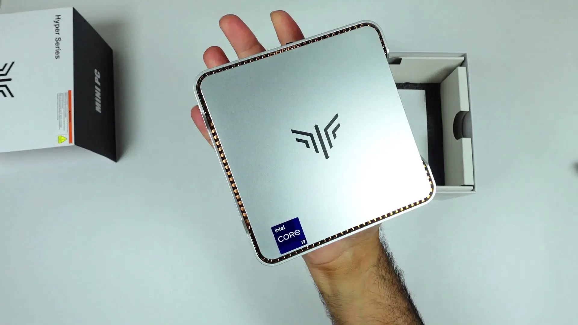 Silver KAMRUI Hyper H2 mini PC resting flat on an open palm, showing the KAMRUI logo and Intel Core badge
