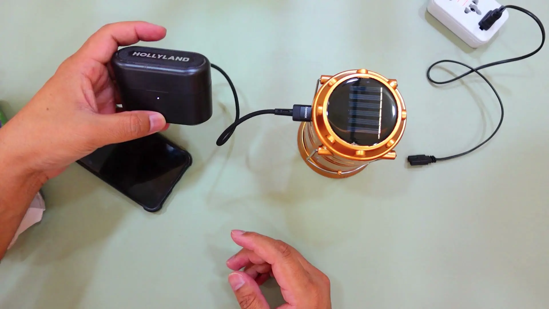 The lantern's USB output connected via cable to a small charging case, powering it as a power bank