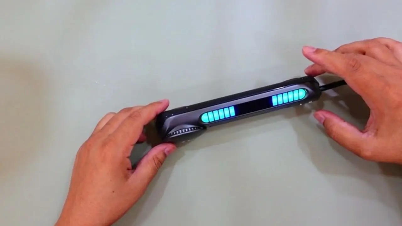 A black car dashboard bar with bright cyan RGB LED segments glowing in two banks across the front panel, held in two hands