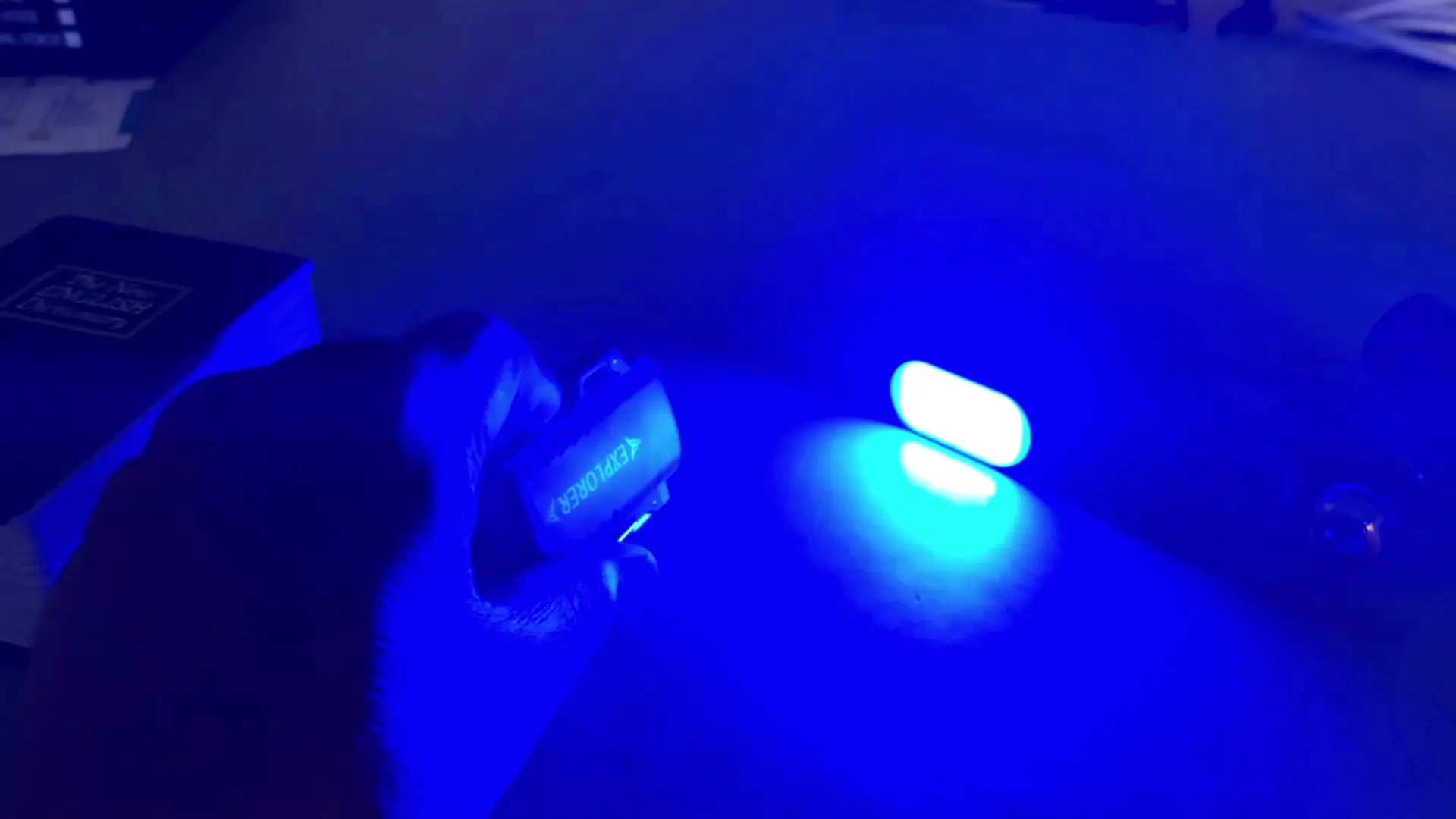 The AOCHUAN magnetic fill light glowing blue, demonstrating its RGB color output