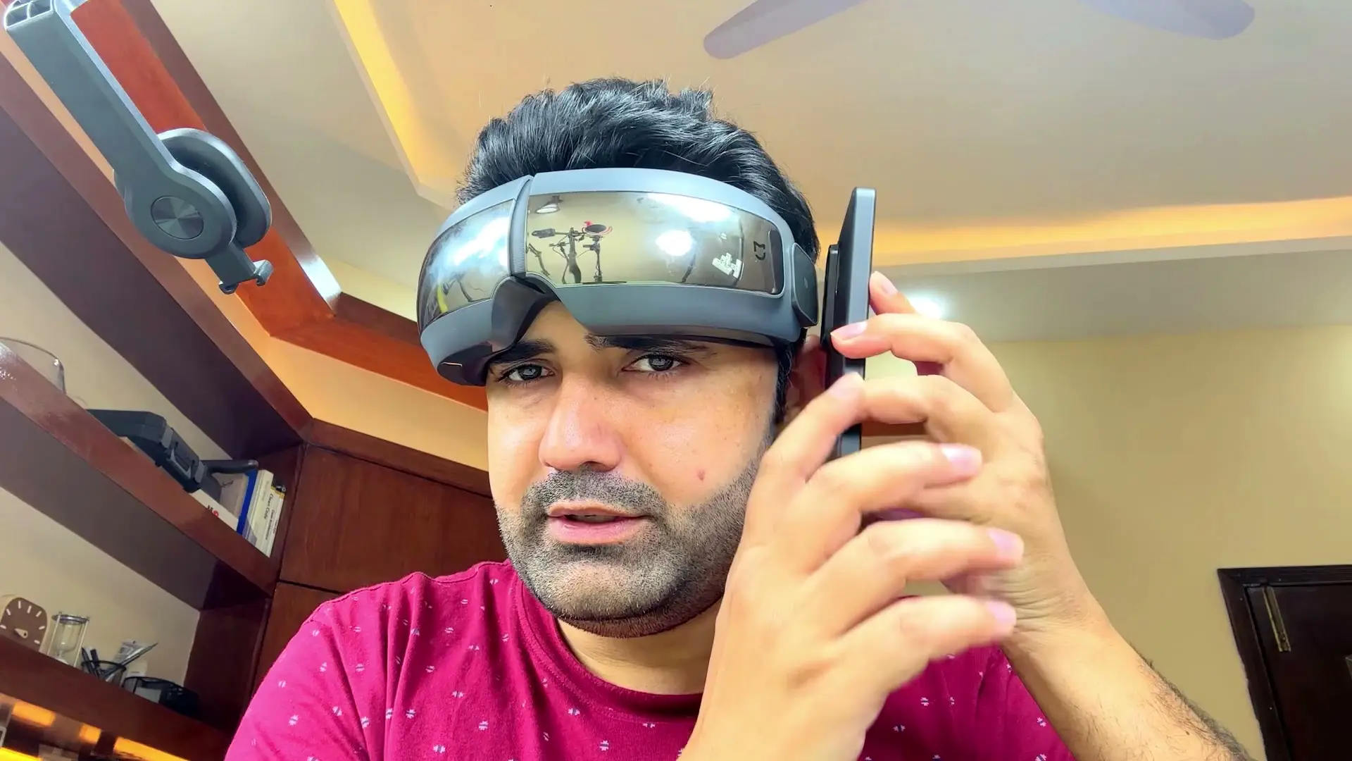 Ramiz wearing the Xiaomi Mijia Smart Eye Massager with reflective visor panels while holding a phone near the NFC tap area